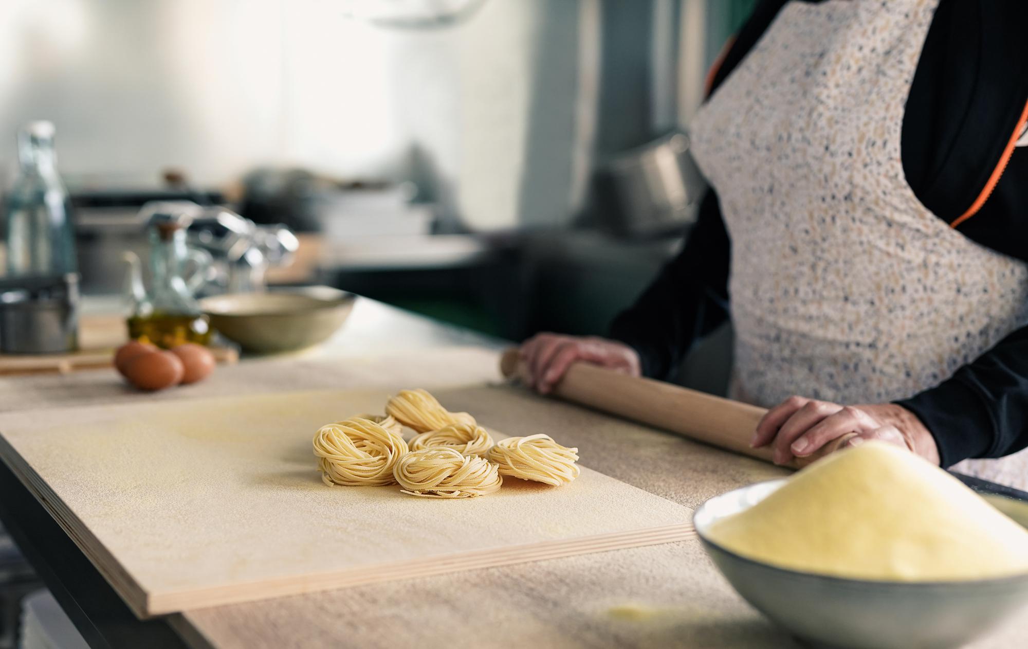Chef che sistema una preparazione di pasta fresca in una cucina calma